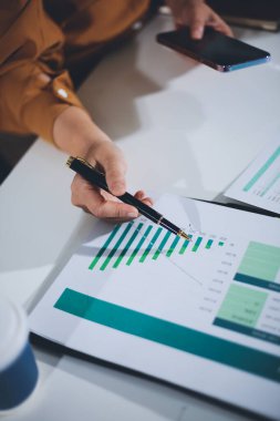 Business woman using calculator to calculate financial report, working at office with laptop computer on table. Asian female accountant or banker making calculations. finances and economy concept