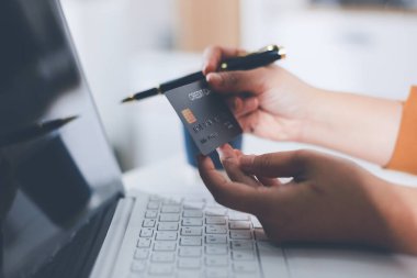 Çevrimiçi ödeme, kredi kartı tutan ve online alışveriş için akıllı telefon kullanan kadının elleri.