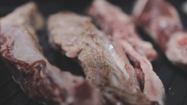 Galbi cızırdayan Kore barbekü deneyimi otantik restoran sahnesi için duman ve ızgara izleriyle dinamik pişirme hareketleri gösteriyor.