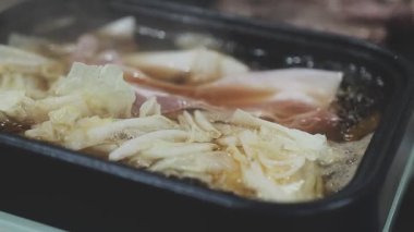 Galbi cızırdayan Kore barbekü deneyimi otantik restoran sahnesi için duman ve ızgara izleriyle dinamik pişirme hareketleri gösteriyor.