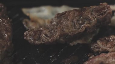 Galbi cızırdayan Kore barbekü deneyimi otantik restoran sahnesi için duman ve ızgara izleriyle dinamik pişirme hareketleri gösteriyor.