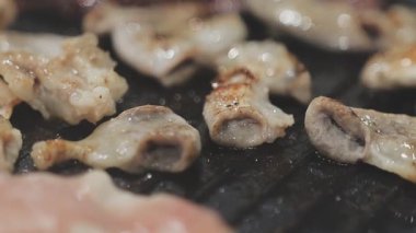 Galbi cızırdayan Kore barbekü deneyimi otantik restoran sahnesi için duman ve ızgara izleriyle dinamik pişirme hareketleri gösteriyor.