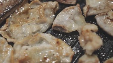 Galbi cızırdayan Kore barbekü deneyimi otantik restoran sahnesi için duman ve ızgara izleriyle dinamik pişirme hareketleri gösteriyor.