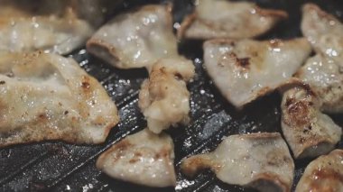 Galbi cızırdayan Kore barbekü deneyimi otantik restoran sahnesi için duman ve ızgara izleriyle dinamik pişirme hareketleri gösteriyor.