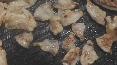 Galbi cızırdayan Kore barbekü deneyimi otantik restoran sahnesi için duman ve ızgara izleriyle dinamik pişirme hareketleri gösteriyor.