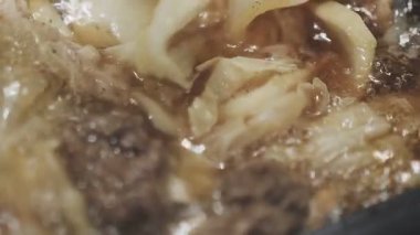 Galbi cızırdayan Kore barbekü deneyimi otantik restoran sahnesi için duman ve ızgara izleriyle dinamik pişirme hareketleri gösteriyor.