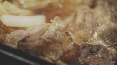 Galbi cızırdayan Kore barbekü deneyimi otantik restoran sahnesi için duman ve ızgara izleriyle dinamik pişirme hareketleri gösteriyor.