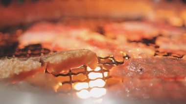 Galbi cızırdayan Kore barbekü deneyimi otantik restoran sahnesi için duman ve ızgara izleriyle dinamik pişirme hareketleri gösteriyor.