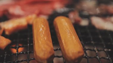 Galbi cızırdayan Kore barbekü deneyimi otantik restoran sahnesi için duman ve ızgara izleriyle dinamik pişirme hareketleri gösteriyor.