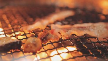 Galbi cızırdayan Kore barbekü deneyimi otantik restoran sahnesi için duman ve ızgara izleriyle dinamik pişirme hareketleri gösteriyor.