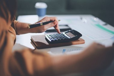 Business woman using calculator to calculate financial report, working at office with laptop computer on table. Asian female accountant or banker making calculations. finances and economy concept