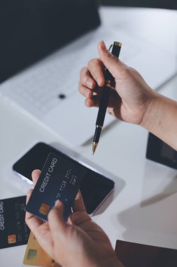 Çevrimiçi ödeme, kredi kartı tutan ve online alışveriş için akıllı telefon kullanan kadının elleri.