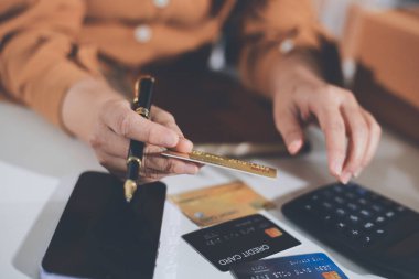 Çevrimiçi ödeme, kredi kartı tutan ve online alışveriş için akıllı telefon kullanan kadının elleri.