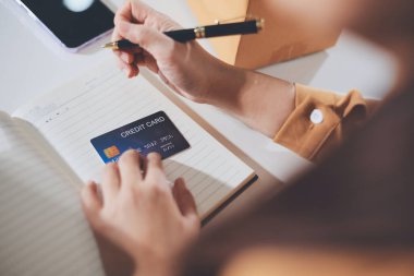 Çevrimiçi ödeme, kredi kartı tutan ve online alışveriş için akıllı telefon kullanan kadının elleri.