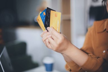 Çevrimiçi ödeme, kredi kartı tutan ve online alışveriş için akıllı telefon kullanan kadının elleri.