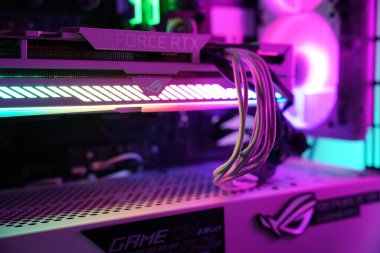 Bu özel oyun bilgisayarı, düşük ışık koşulları altında iç tasarım ve teknolojiyi gösteren canlı ışıklarla parlayan bir grafik kartı içerir..