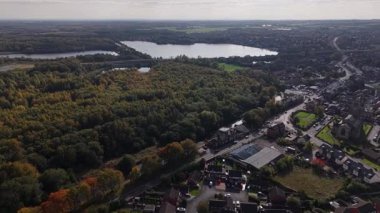 Göz kamaştırıcı bir hava manzarası canlı bir sonbahar manzarası, renkli ağaçlar, sakin bir göl ve yakınlarda büyüleyici bir kasaba sergiliyor. Huzurlu manzara, doğanın güzelliğini takdir etmeye davet ediyor..