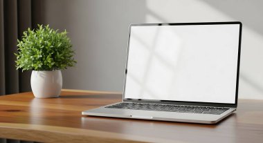 Pürüzsüz, modern bir dizüstü bilgisayar yumuşak, doğal ışıkla yıkanmış canlı yeşil bir saksı bitkisinin yanında, sıcak ahşap bir masada oturuyor..