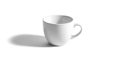 Sade, zarif, beyaz bir kahve fincanı, yumuşak ve dağınık bir gölgeye karşı sunulur..