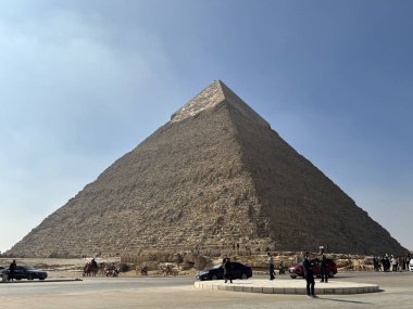 Kahire, Mısır - 01: 15 2025: Büyük Giza Piramidi, Mısır, açık mavi gökyüzünün altında. İnsanlar ve arabalar üsten görülüyor..