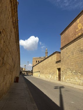 Kahire, Mısır 'da güneşli bir sokak manzarası, eski binalar ve tek bir bulutla berrak mavi bir gökyüzü..