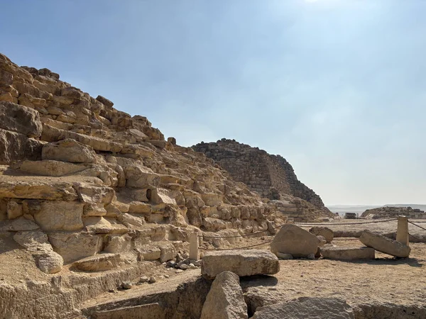 Kahire, Mısır - 01: 15 2025: Antik taş kalıntıları ve kalıntıları berrak, parlak bir gökyüzü altında. Görünür katmanları ve kaya oluşumlarıyla antik yapılar..