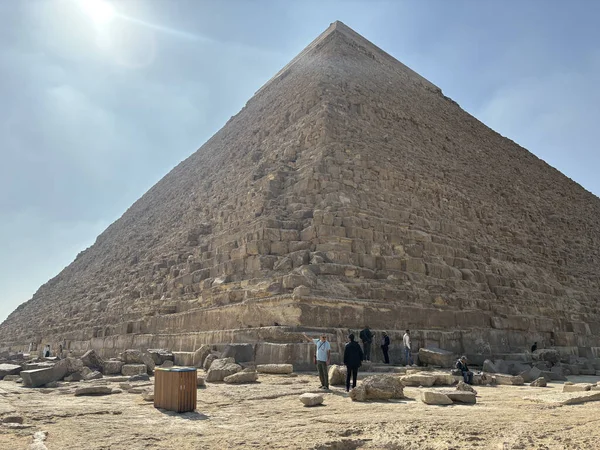 Kahire, Mısır - 01: 15 2025: Büyük Giza Piramidi, Mısır. Turistler antik yapının tabanında parlak, güneşli bir gökyüzünün altında görülebilirler..