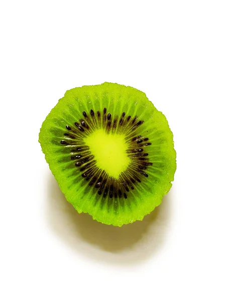 Beyaz arka planda canlı bir kivi dilimi, yeşil et ve siyah tohumlarını sergiliyor..