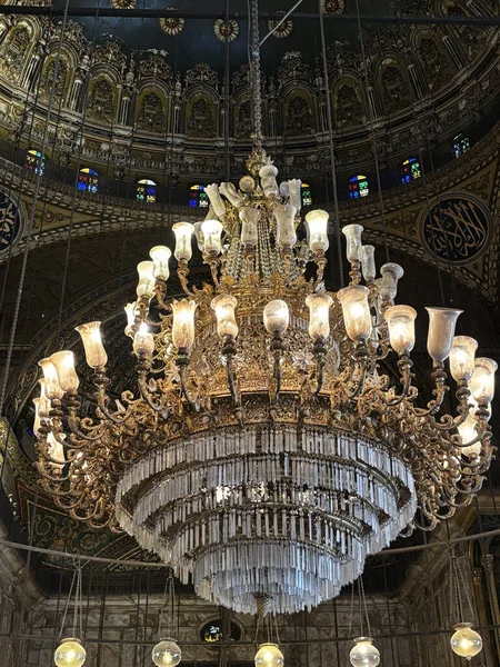 Son derece süslü, süslü bir tavandan sarkan küçük vitraylı bir avize..