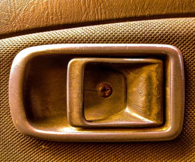 Arabanın iç kapı kolunun kumaş desenli ve tek vidayla yakın çekimi..