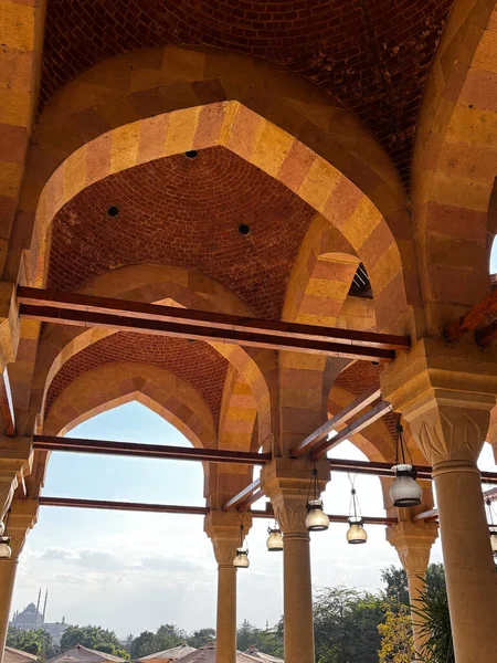 Tuğla tavanlı kemerli taş yapı. Sütunlar ve kemerler karmaşık desenler yaratır. Görünür binalarla dış görünüş.