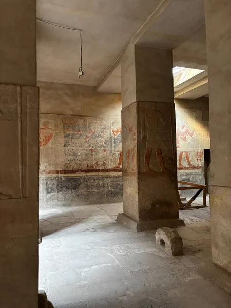 Boyalı duvarları ve sütunları olan eski bir Mısır yapısının içi. Taş mimarisi ve eski bina görünür..