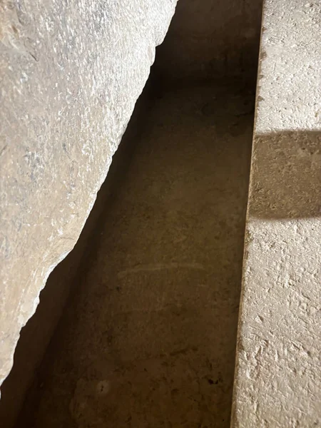 Taş veya beton yüzeylerin soyut görünümü, dokuları ve gölgeleri gösterir.