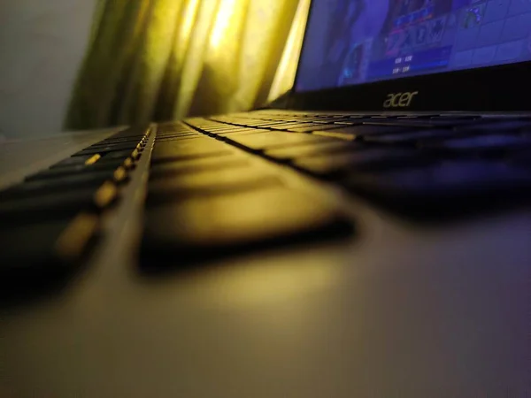 Bir Acer dizüstü bilgisayarının klavyesinin yakın plan görüntüsü bulanık arka planda, yumuşak tonlarla aydınlatılıyor. Anahtarlara odaklan..