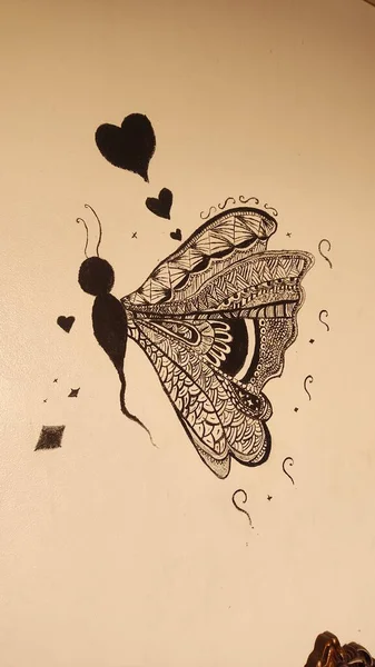 Bej bir yüzeye kalp ve elmas şekilli Zentangle 'dan esinlenilmiş bir kelebek. Siyah ve beyaz ayrıntılı desen.