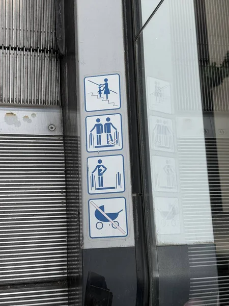 Bebek arabalarının yasaklanması ve diğer uyarılar da dahil olmak üzere sembollü yürüyen merdiven güvenlik işareti.