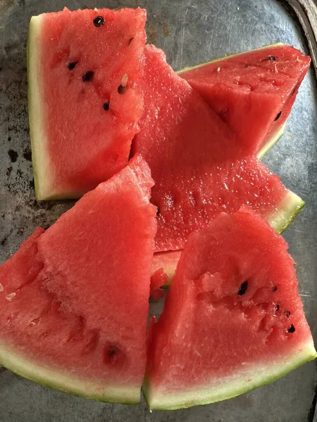 Karanlık bir yüzeyde olgun karpuz dilimleri. Ferahlatıcı, sulu yaz meyvesi..