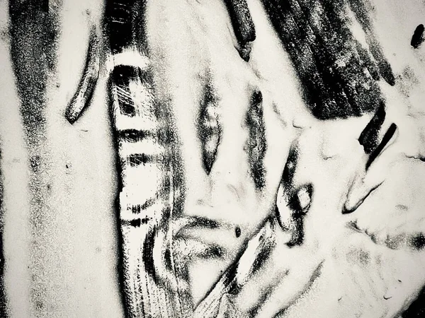 Soyut siyah ve beyaz boya darbeleri, dokulu ve dinamik bir görüntü yaratır. Yakın çekim..