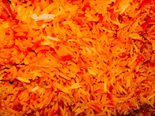 Turuncu-kırmızımsı bir tonu gösteren pilavın yakın plan görüntüsü. Taneler belirgin ve hafifçe parıldıyor..