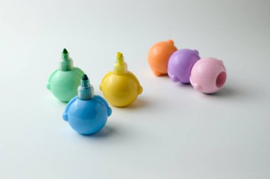 Temiz beyaz arka planda çocuklar için sıralanmış renkli dolma kalemler. Eğitim malzemeleri, çocuk sanat projeleri ya da okul malzemeleri için mükemmel, neşeli ve yaratıcı bir ortam.