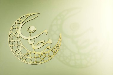 Beyazlı İslami geometrik kemer süsü yumuşak yeşil arka planda karmaşık bir gölge bırakıyor. Ramazan ve bayram kutlamaları, İslam bayramı terfileri ve zarif afişler ve poster tasarımları için mükemmel.