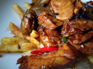 Canlı bir Çin Char Siu domuz eti, yanında taze tuz ve biber cipsi ile birlikte, zengin siyah fasulye ve yeşil biber sosu..