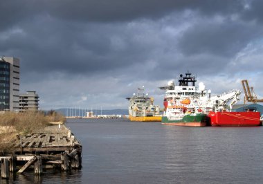 Leith, Edinburgh 'un hareketli limanına, dramatik karanlık ve bulutlu gökyüzünün altında çok sayıda büyük açık deniz gemisi yanaştı..