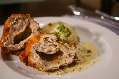 Altın sarısı, ekmekli hindi göğsü, ikiye bölünmüş taze et ve zengin bitki sosu. Hafif bir garnitür ve taze maydanozla süslenmiş..