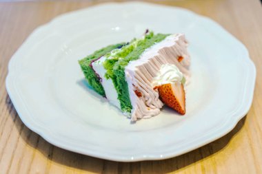 Kremalı ve taze çilekli canlı bir kibrit pastası. Beyaz bir tabakta mükemmel sunulmuş..