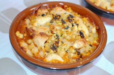 Lezzetli bir Akdeniz sosu ve çıtır çıtır soslu ve biberli altın fırında tavuk tapası içeren seramik kasenin iştah açıcı yakın çekimi..