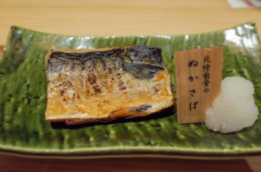 Mükemmel ızgara uskumru fileto, çıtır çıtır deriyle, rendelenmiş daikon turpu ile servis edilir..