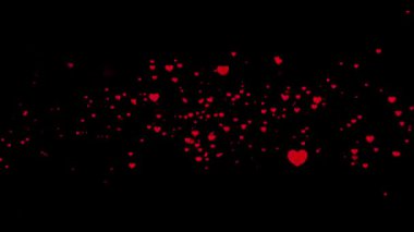 Güzel kırmızı kalp parçacıkları karanlık bir zemin döngüsünde yüzüyor ve parıldıyor.