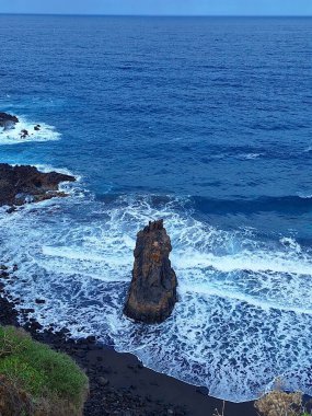 Kayaların ve okyanusun fantastik manzarası. Engebeli kayaların ve engin, parıldayan okyanusun fantastik manzarası hayranlık uyandırıcı ve unutulmaz bir doğal manzara yaratır..