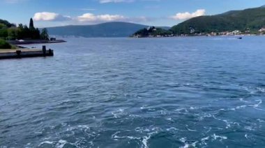 Berrak mavi gökyüzünün altında dingin suların ve yeşil dağların manzarası huzur ve güzellik getiriyor.